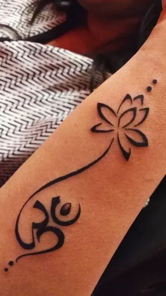 Minimal lotus tribal tattoo growing from Aum: inked placement tattoo photo